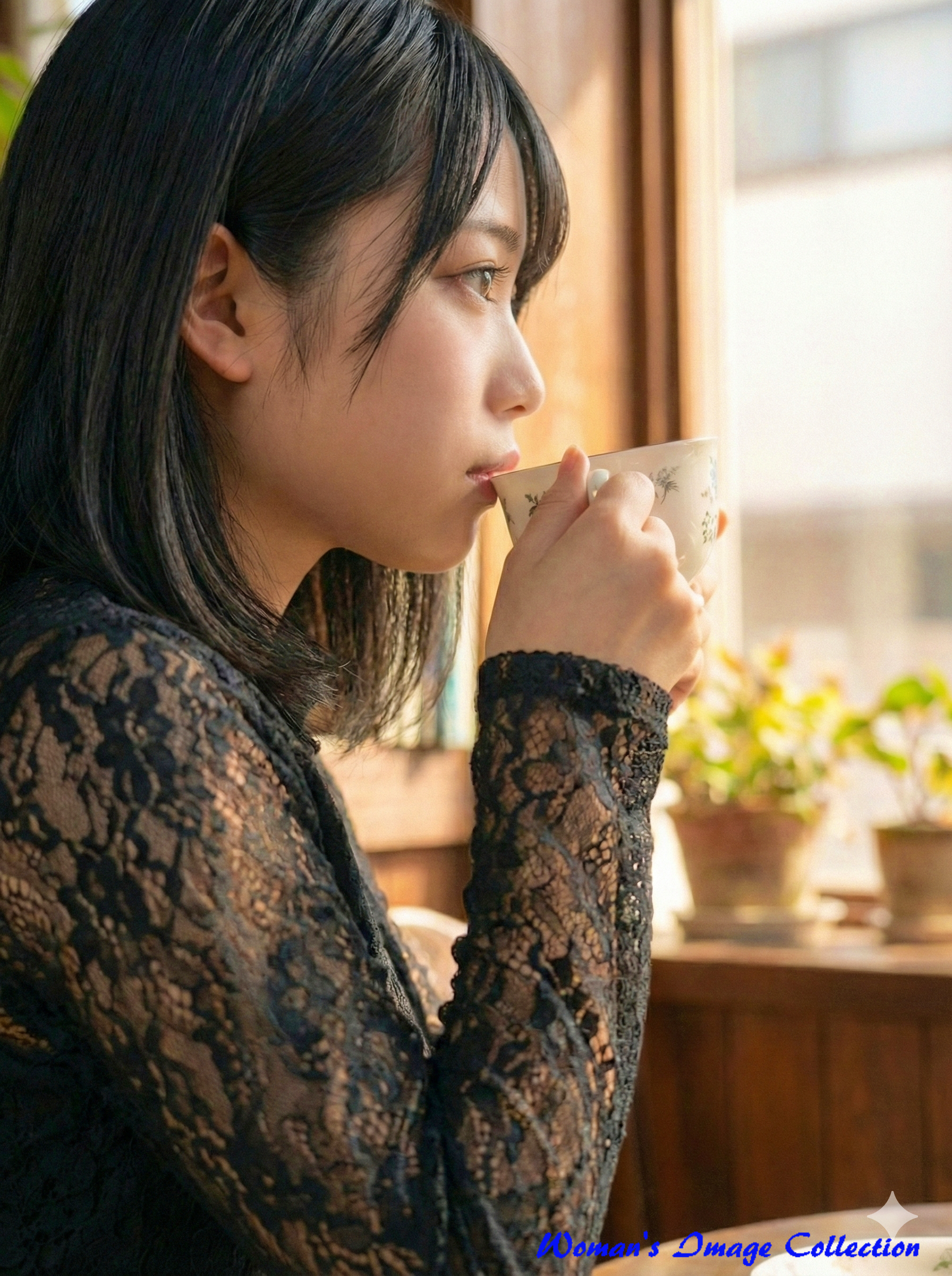 室内でティーカップを持つ黒髪の日本人女性の横顔、レースの黒い服、窓際の自然光