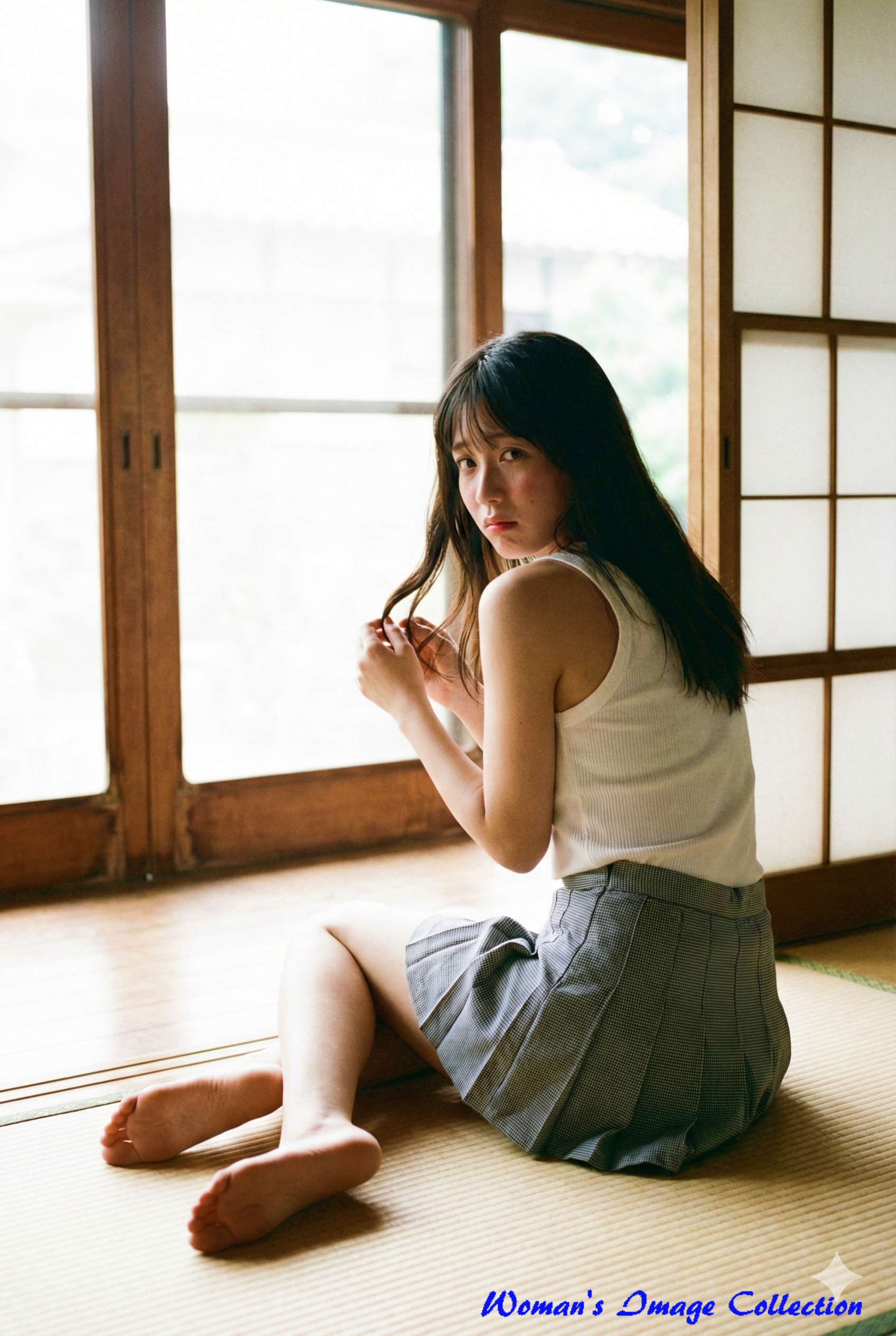 畳に座り背中越しに振り返る女性。窓からの自然光が差し込む昭和レトロな雰囲気。